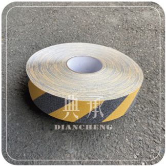 一卷黑黃斜紋相間色的金鋼砂止滑膠帶